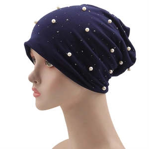 Détail du bonnet bleu foncé orné de perles blanches élégantes et de strass scintillants