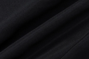 Close-up of black knitted fabric showing premium soft texture and fine weaving detail