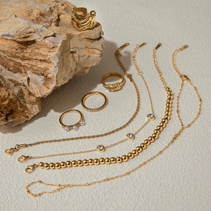 Golden titanium steel jewelry set with pearls and zircon crystals on natural stones