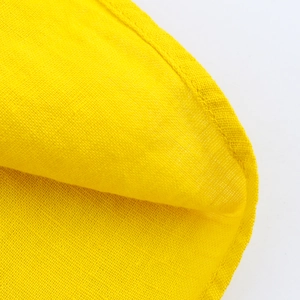 Close-up of yellow linen dress fabric texture with high-quality edge stitching details