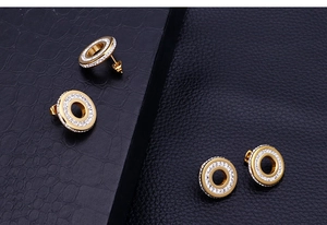 Gros plan de boucles d'oreilles rondes ajourées avec cristaux sur cuir noir chic