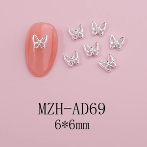 Detailed silver hollow butterfly nail charm with mini diamond on pink nail surface