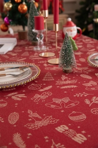 Close-up of red Christmas tablecloth featuring HO HO HO patterns and festive decor