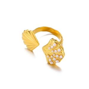 Detail of 18k gold shell ring featuring smooth gold finish and white pearl inlay accents