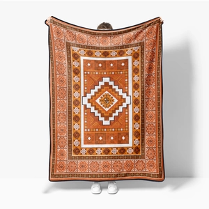 Detail of bohemian flannel blanket with geometric tribal patterns in orange and caramel