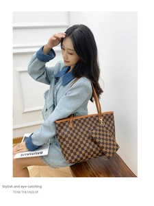 Detail shot of a brown checkerboard tote bag with a matching small hanging pouch charm