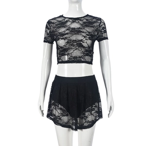 Detail van de zwarte kant tweedelige set met bloemen opengewerkte textuur op top en rok