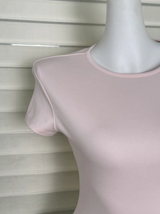 Detailed close-up of pink crew neck T-shirt featuring fine ribbed knit fabric texture