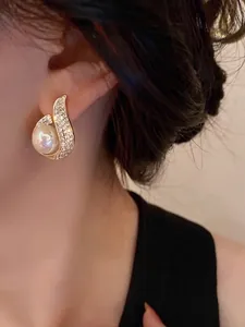 Elegant gold drop earrings with mermaid pearl and crystals on model, French luxury style