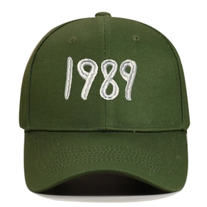 Detailed view of white 1989 3D embroidery on deep green cotton canvas baseball cap