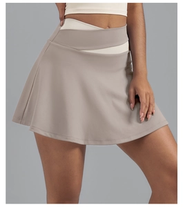 Detail van de gekruiste hoge tailleband en kleurblokken op de khaki tennisrok