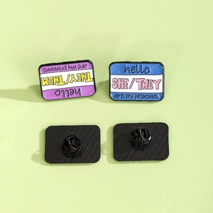 Rectangular enamel pronouns pins featuring She/They and They/Them text on metal badges