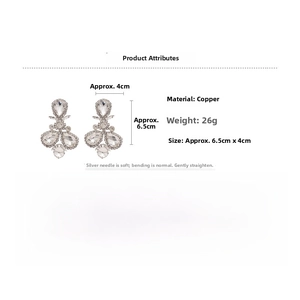 Macro view of crystal teardrop earrings with silver pins and dimension measurements