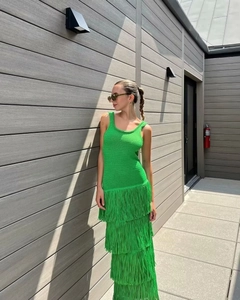 Détail d'une robe en maille vert citron sans manches avec jupe à franges multicouches
