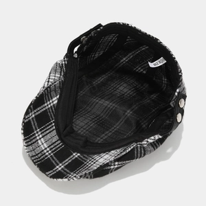 Classic black and white checkered ivy cap with metal buttons and interior lining detail