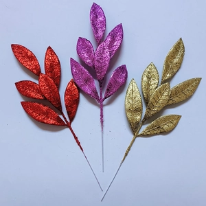Dettaglio di aghi di pino artificiali glitterati nei colori rosso, viola e oro