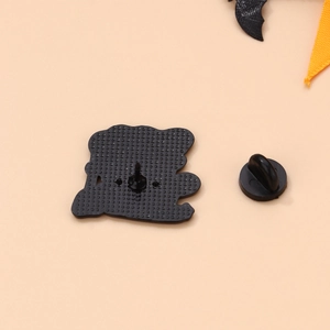 Detail view of the enamel brooch back with non-slip texture and black rubber pin clutch