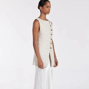 Chic beige sleeveless top with side buttons and slit, paired with matching skirt set