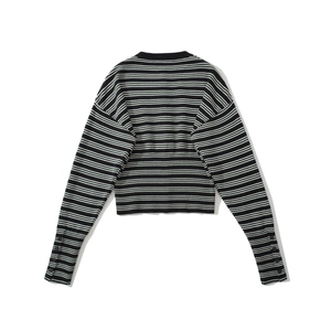 Detail of black and white striped knit cardigan with button cuffs and soft texture