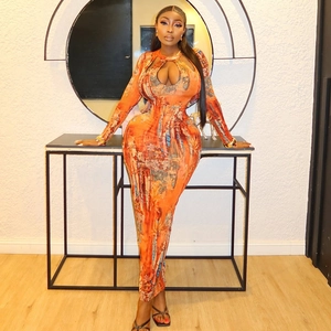 Detail of artistic orange print dress with hollow-out chest and long sleeves