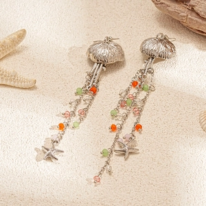 Detail showing jellyfish earrings with colorful beads and starfish on sandy background