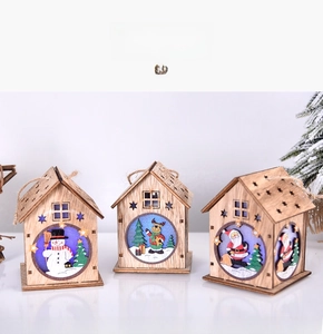 Close-up of three glowing wooden Christmas houses with snowman, elk, and Santa motifs