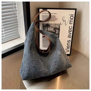 Detailed macro view of diamond-quilted denim tote bag with premium brown leather straps