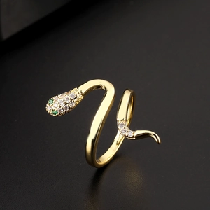 Macro shot of gold snake ring with sparkling white cubic zirconia and green gem eyes