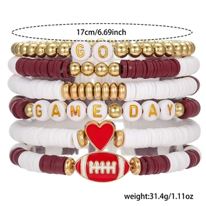 Detail of stacked rugby-themed elastic bracelets with heart charms and GAME DAY letters
