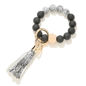 Detail of matte black and marble silicone bead keychain with wooden bead and tassel