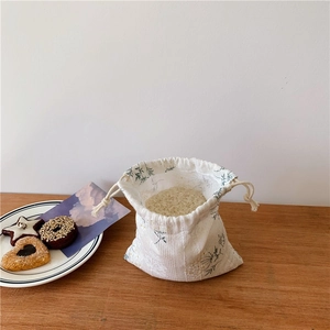 Detail of a floral drawstring pouch with green leaf print for organizing kitchen sundries
