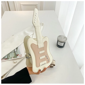 Detail of guitar-shaped crossbody bag with star studs and wide fabric shoulder strap