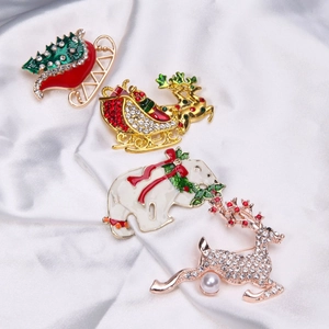 Detailed group shot of Christmas enamel brooches with reindeer and polar bear on white silk