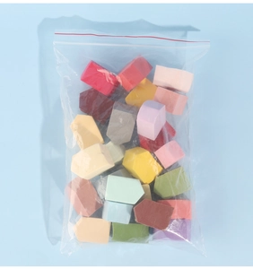Macro view of multi-color wedge makeup sponges in a resealable zip-lock bag