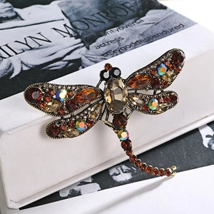 Macro detail of vintage dragonfly brooch with crystal wings and amber rhinestones