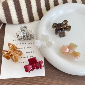 Five assorted acetate bow hair claws in marble and tortoiseshell patterns for women