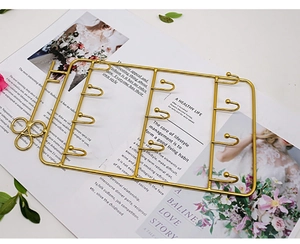 Detail of gold metal jewelry organizer rack featuring multi-hooks and clover handle