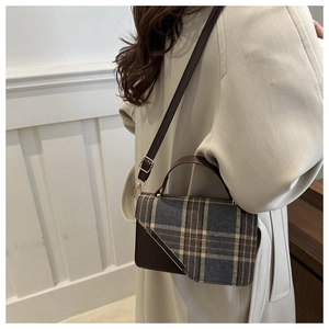 British style checkered handbag with leather trim shown on model wearing a beige trench coat