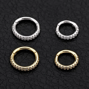 Detail of four S925 sterling silver septum rings with cubic zirconia in gold and silver