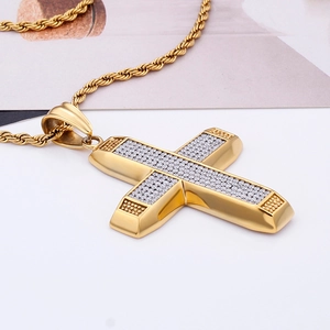 Macro shot of gold-plated twisted rope chain and iced-out cross pendant with clear crystals
