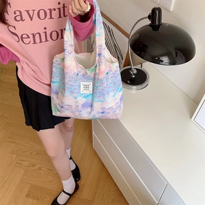 Dettaglio della borsa shopping in tela con motivi floreali artistici in lavanda e verde