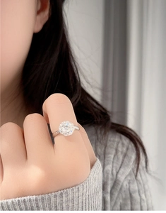 Macro side view of a 1-carat moissanite ring in silver finish worn by a model