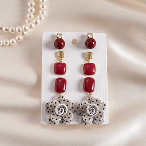 Retro six-piece acrylic flower drop earrings on white card with soft silk background