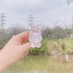 Macro shot of bear phone grip with colorful glitter sequins held in hand outdoors