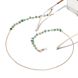 Golden chain eyewear holder with green natural stones on a clean white background