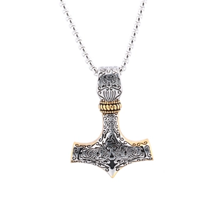 Detailed view of Viking Thor hammer pendant in gold and silver steel relief carving