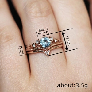 Elegant rose gold princess crown double ring set with a 7mm light blue round gemstone
