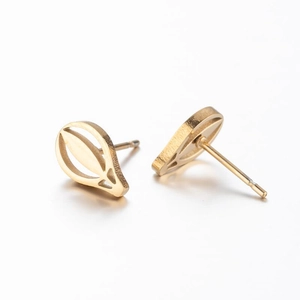 Macro shot of minimalist gold balloon-shaped stud earrings showing smooth metal texture