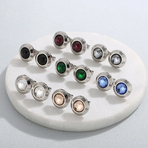 Elegant vintage stainless steel earrings with multi-color crystal stones on a marble base