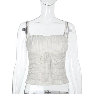 Close-up detail of white lace camisole with ruching and delicate ribbon bow accent